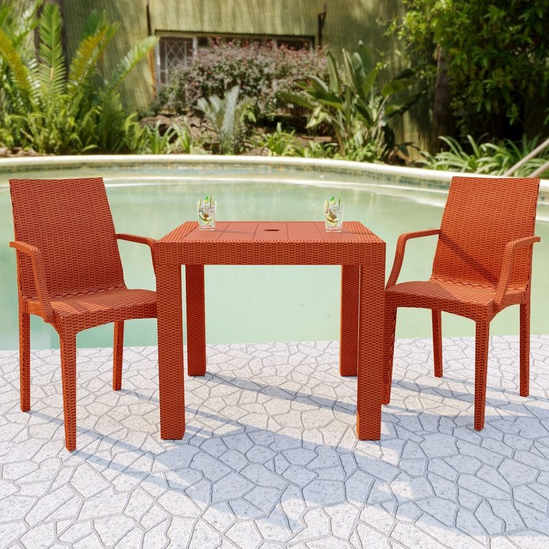LeisureMod Weave Mace Indoor/Outdoor Chair (With Arms) Orange at Table.