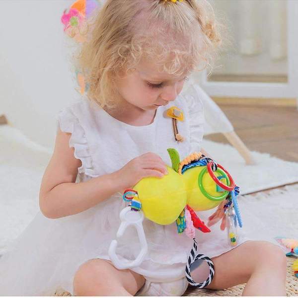 Child playing with a colorful baby toy on a light background.