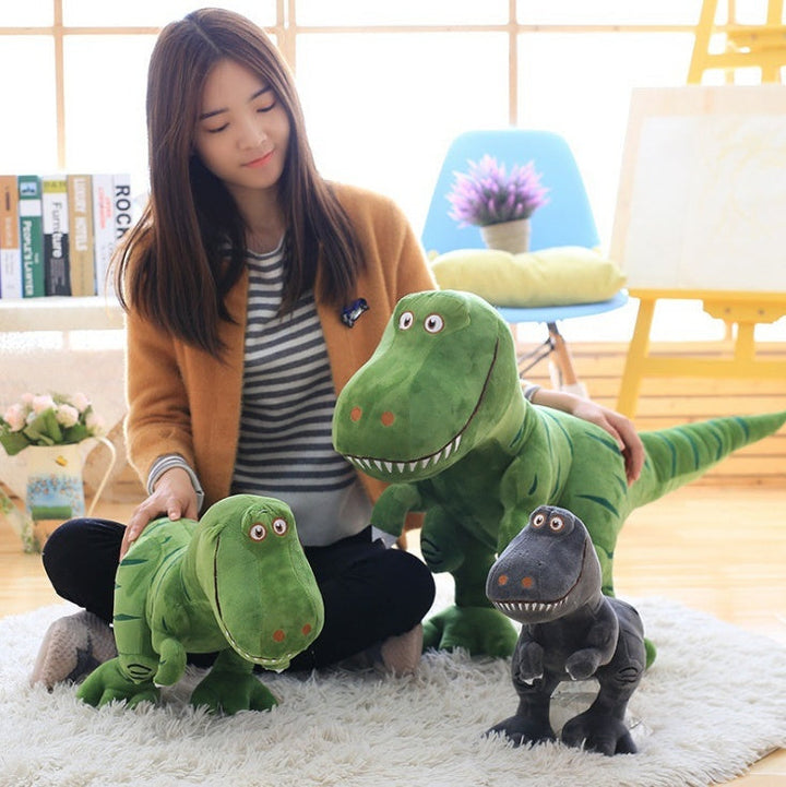 Woman holding three dinosaur plush toys in a room with books and decor.
