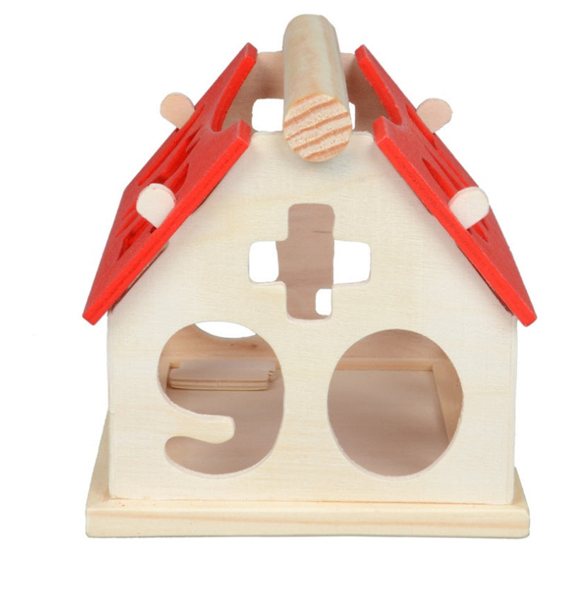 Wooden toy with red roof and various cutouts on a white background.