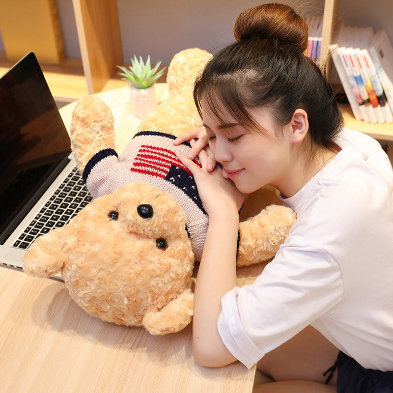 Woman resting her head on a large teddy bear next to a laptop on a desk.