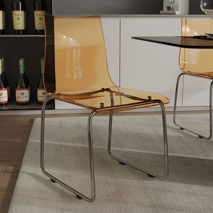 LeisureMod Lima Modern Acrylic Chair Amber at Table.