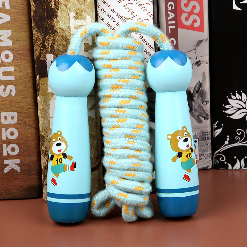 Children's jump rope with cartoon bear design on a wooden surface.