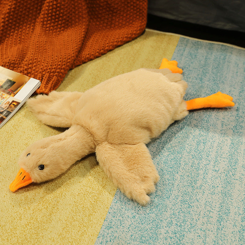Plush toy duck on a textured surface with a magazine in the background.