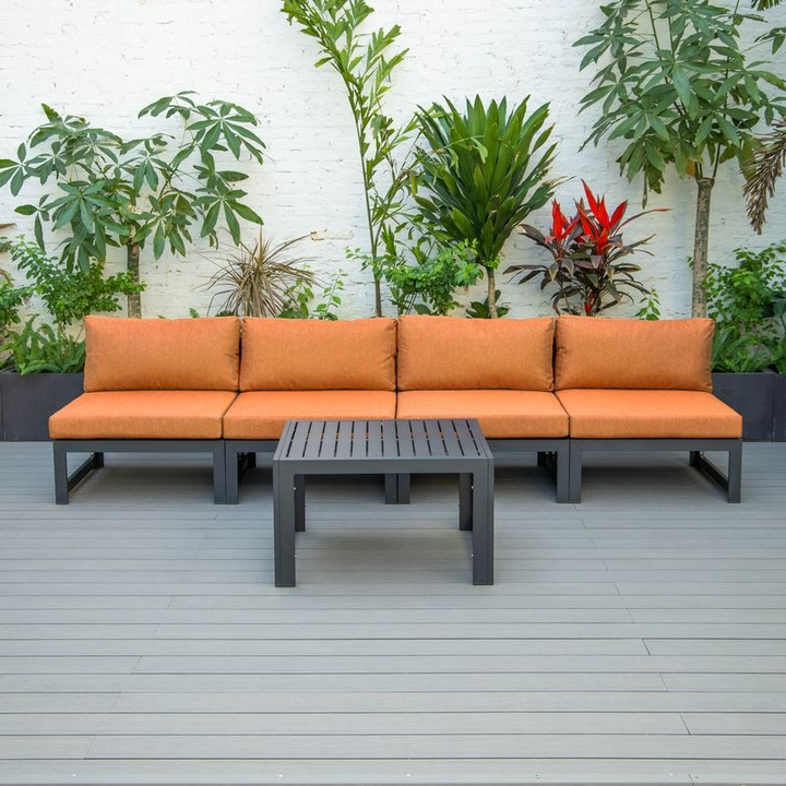 LeisureMod Chelsea 5-Piece Middle Patio Chairs and Coffee Table Set Black Aluminum with Cushions Orange on Deck.