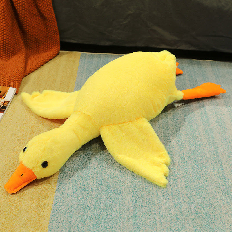 Yellow plush duck toy on a textured surface with a dark background.