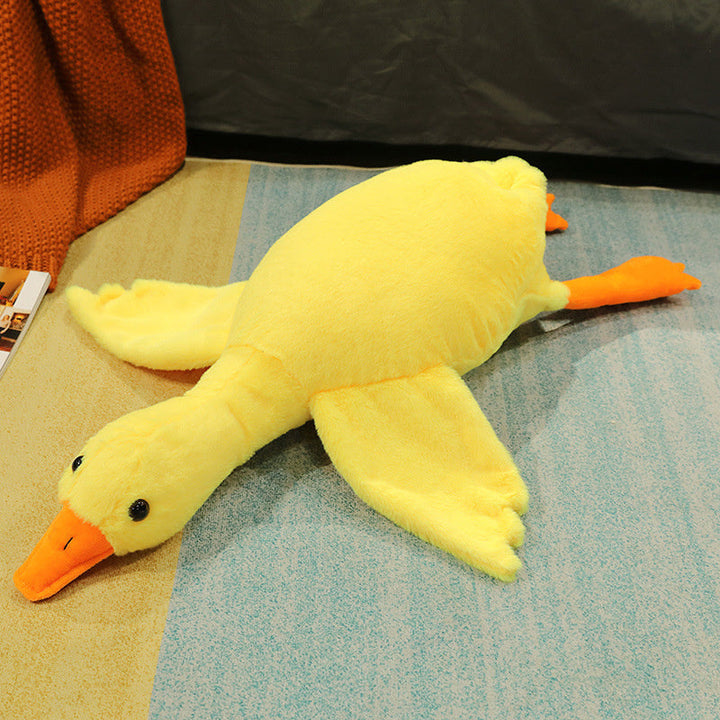 Yellow plush duck toy on a textured surface with a dark background.