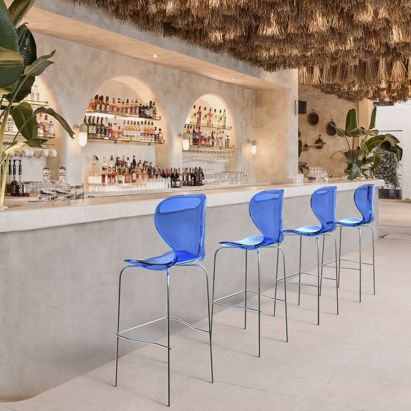 LeisureMod Oyster Acrylic Barstool with Steel Frame in Chrome Finish in Transparent Blue at Bar.