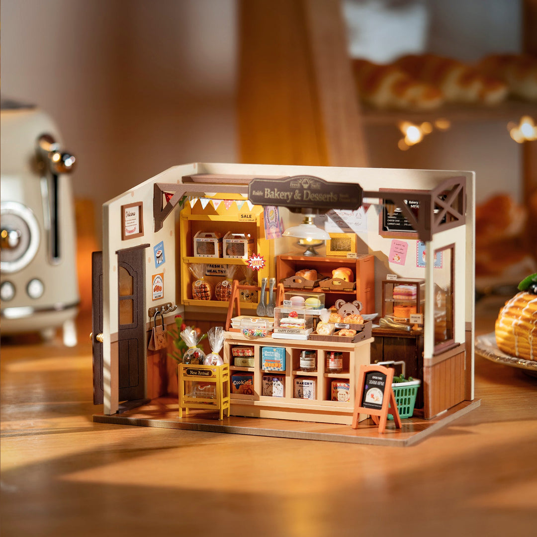 Miniature bakery model with various items and a vintage refrigerator in the background.