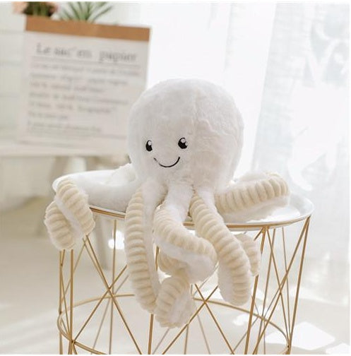 White plush toy on a small round table with a light background.