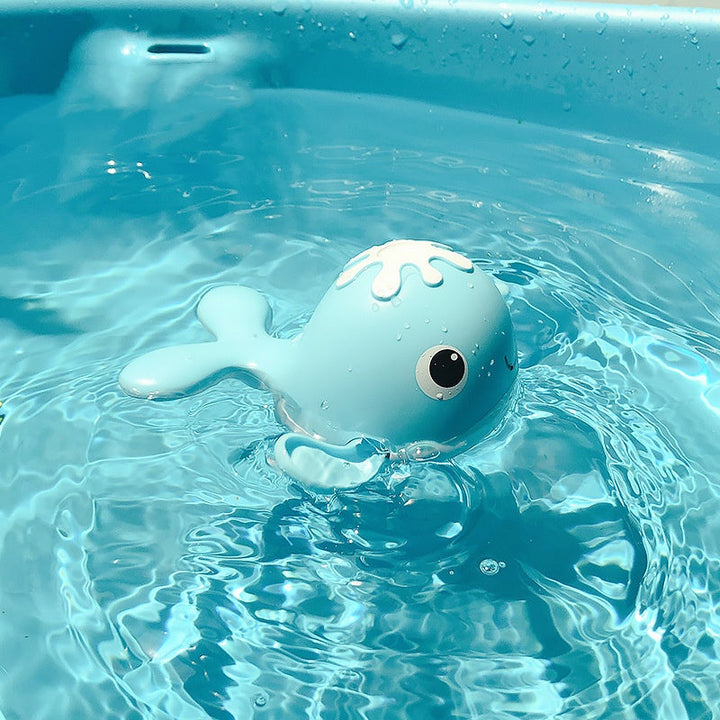 Blue whale-shaped toy floating in clear blue water.