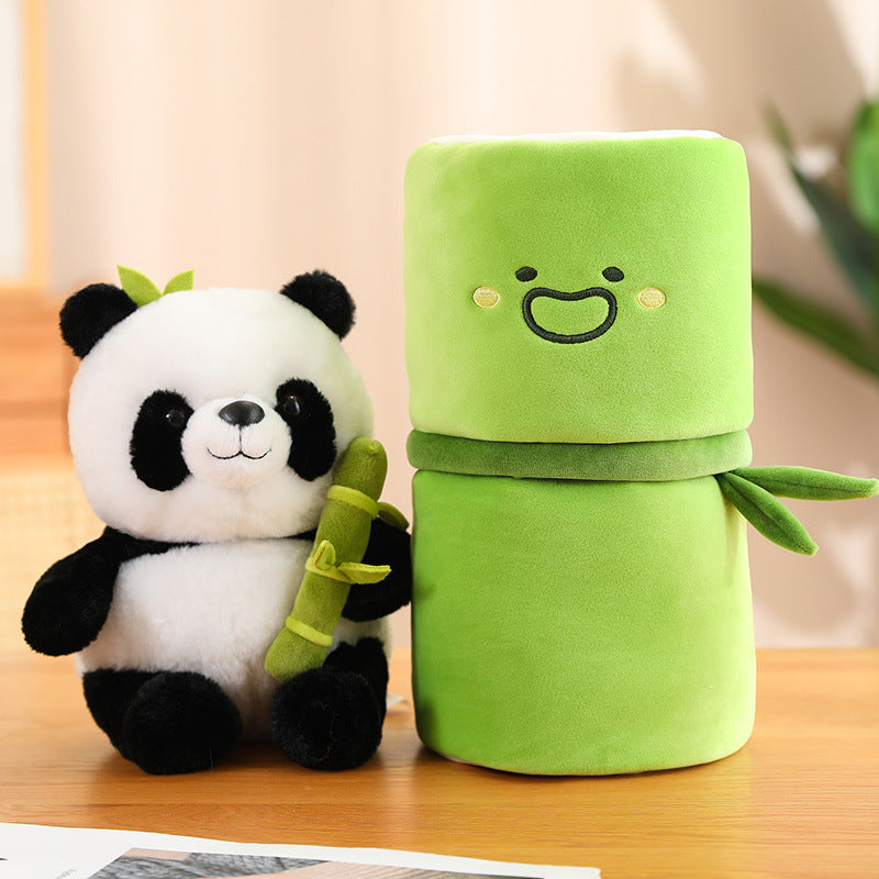 Plush panda toy with a green plush robot on a wooden surface.