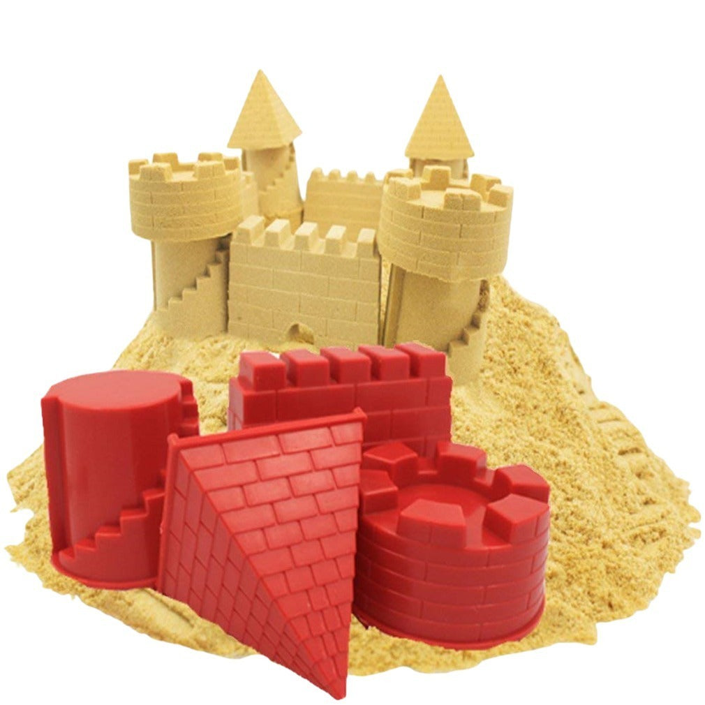 Sandcastle mold set with red molds and yellow sand on a white background.