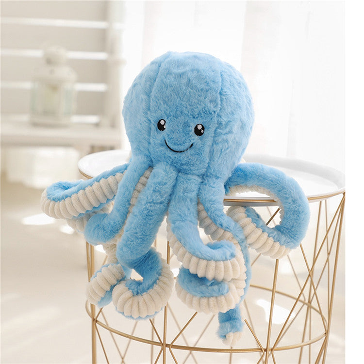Blue plush octopus toy on a gold wire stool with a blurred background.