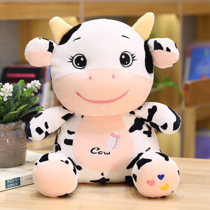 Plush cow toy on a table with a blurred background.