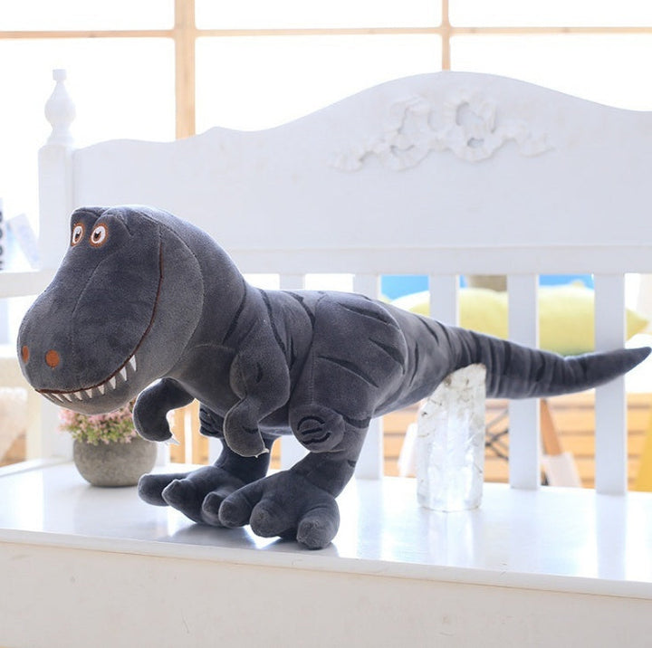 Gray dinosaur plush toy on a white surface with a blurred background.