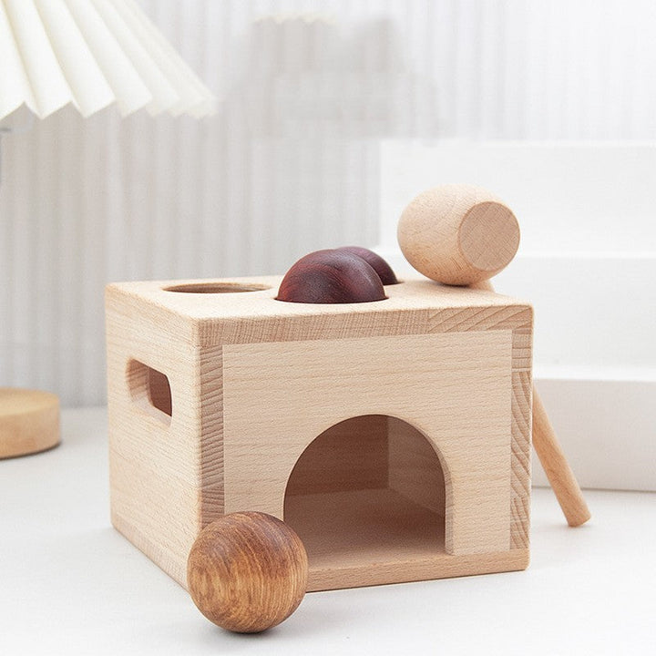 Wooden toy with cylindrical blocks on a white surface.