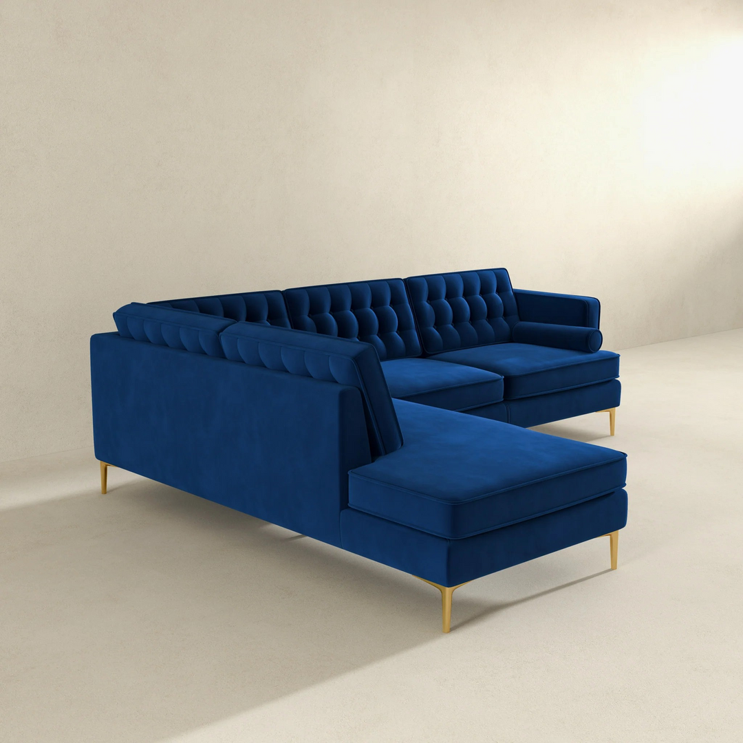 Blue velvet sectional sofa on a beige background.