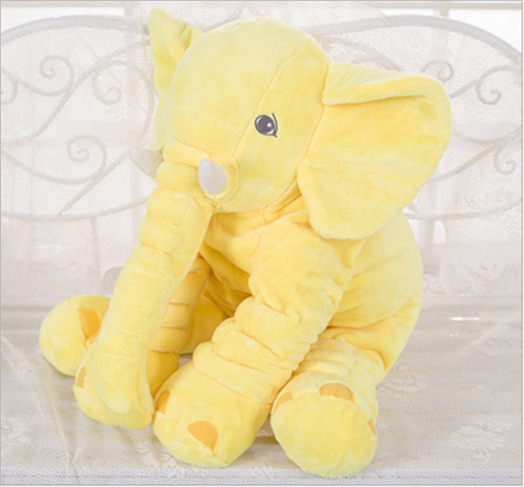 Yellow plush elephant toy on a white surface.