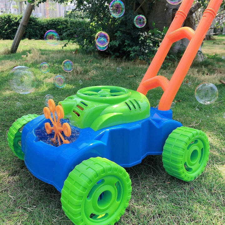 Toy bubble mower on grass with bubbles in the air.