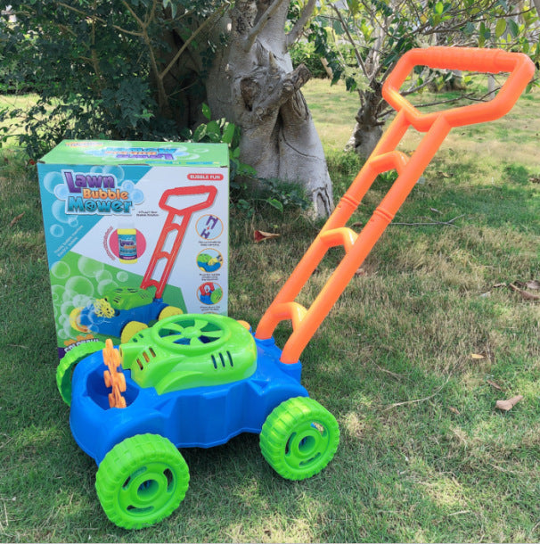 Toy lawn mower with bubble machine on grass next to its packaging.