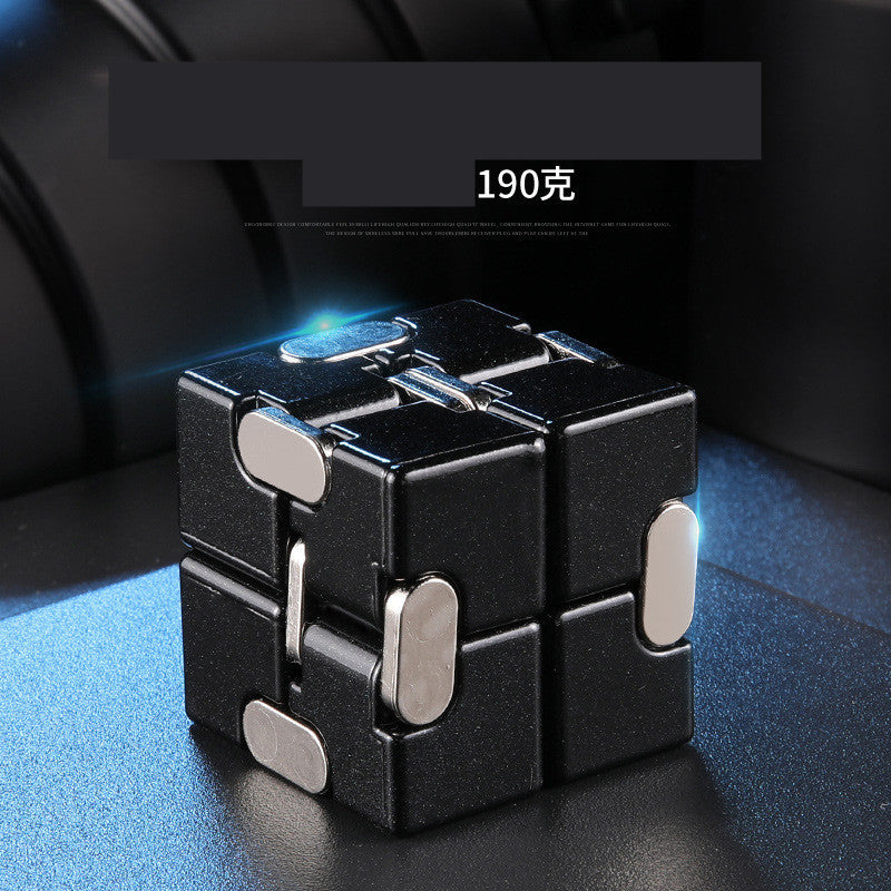 Black and silver fidget cube on a dark surface with text overlay.