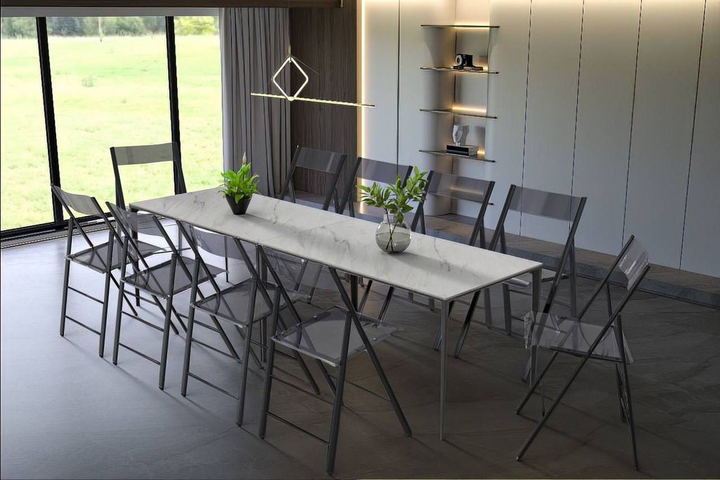 LeisureMod Menno Modern Acrylic Folding Chair Black Frame with Transparent Black Seat at Table.