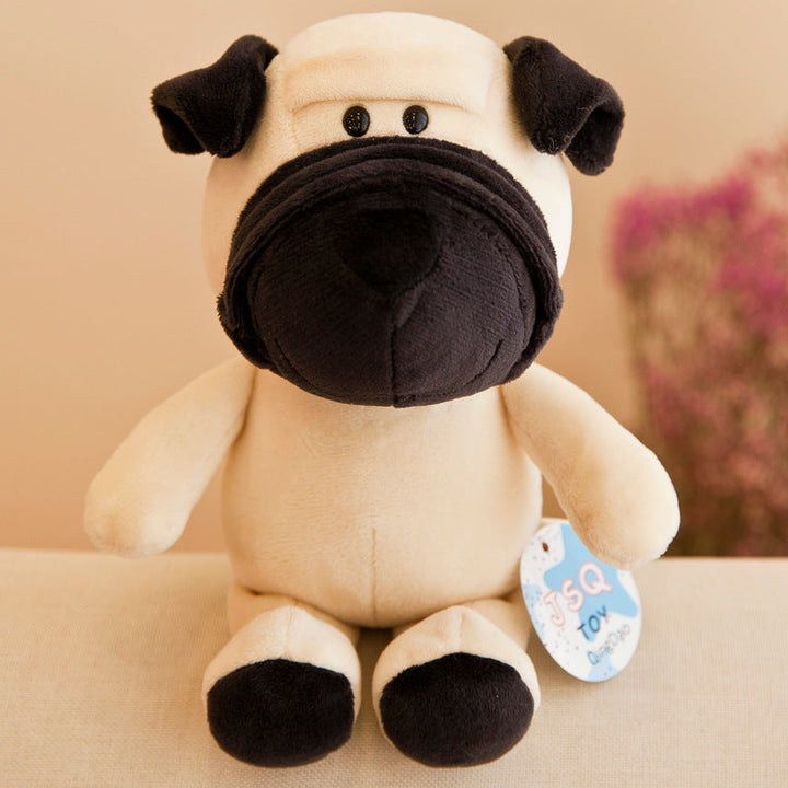 Plush toy dog with a black nose on a beige surface.