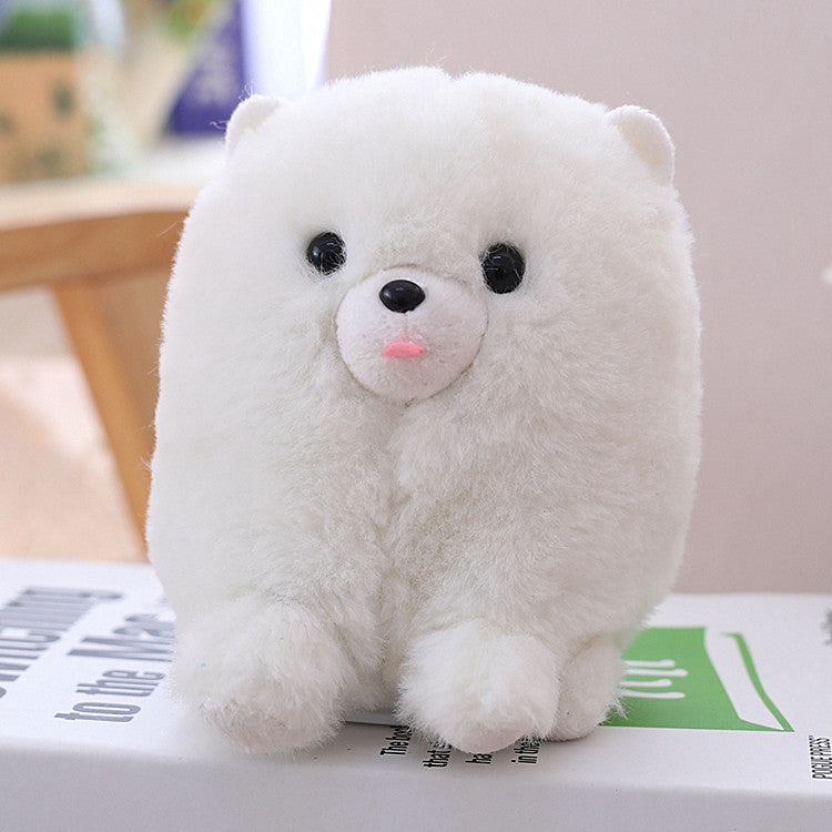 White plush toy bear on a surface with a blurred background.