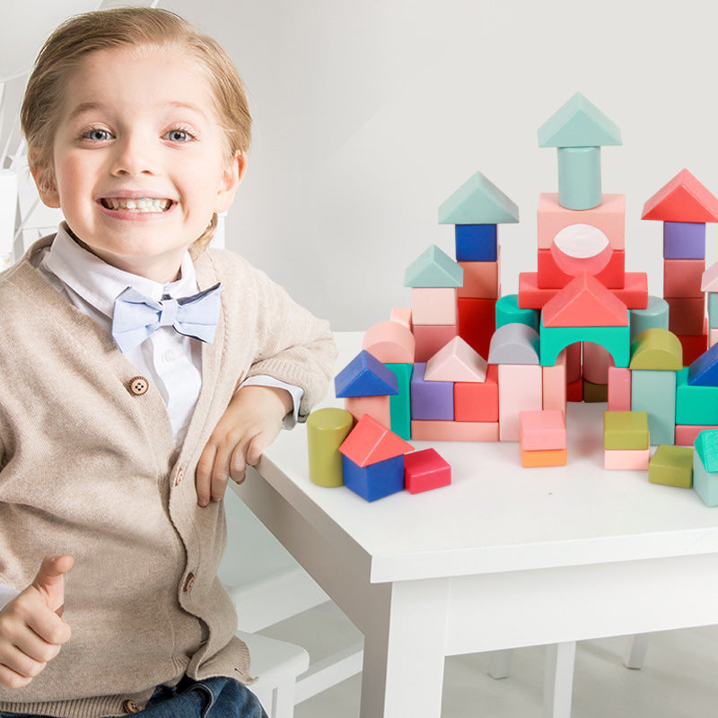 Child playing with colorful building blocks on a white table.