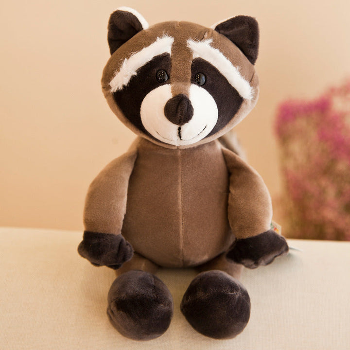 Plush raccoon toy on a light surface with a blurred background.