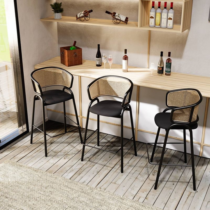 LeisureMod Ervilla Wicker Bar Stool with Fabric Seat and Black Steel Frame in Black Leather at Bar.