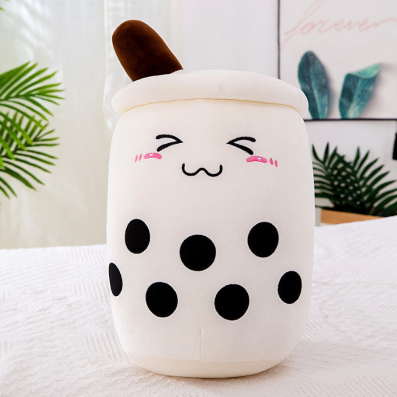 Plush toy resembling a bubble tea cup with a face on a white surface.