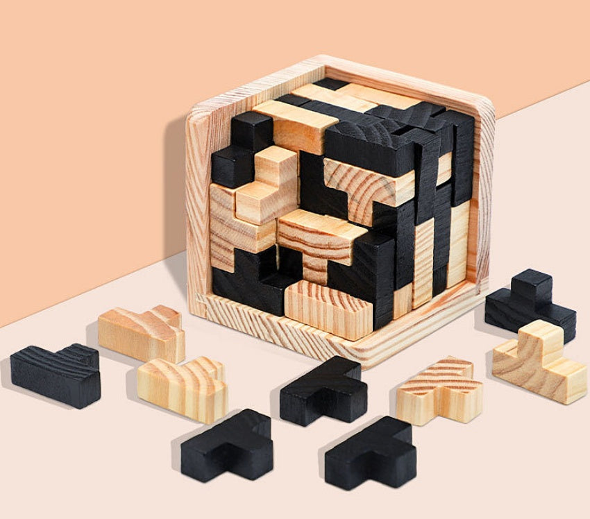 Wooden puzzle with black and beige pieces on a light pink background.