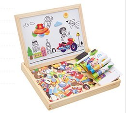 Children's art set with drawings on paper and crayons in a wooden box.