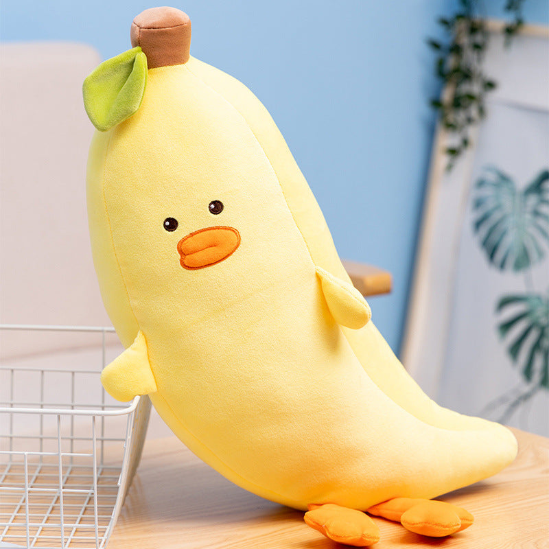 Plush toy shaped like a banana with a face on a wooden surface.