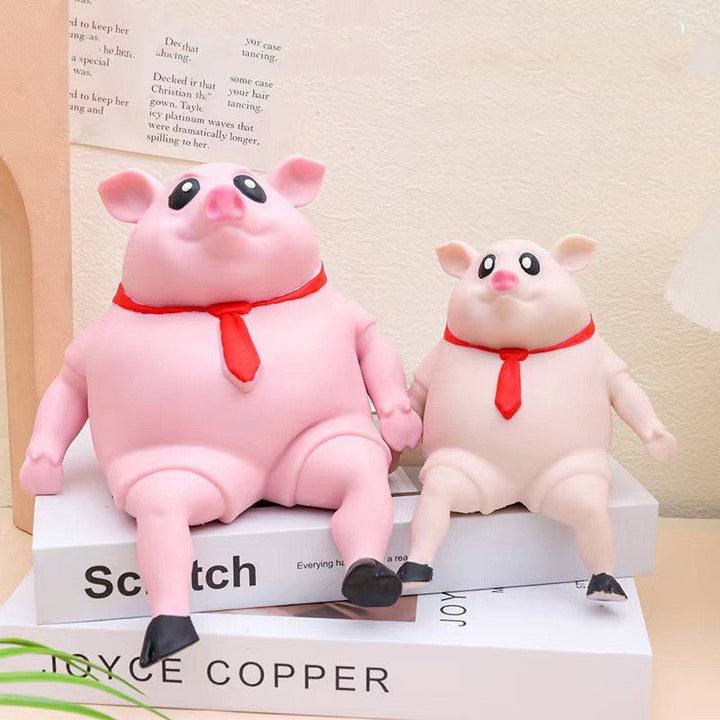 Two pink pig figurines with red bows sitting on a book.
