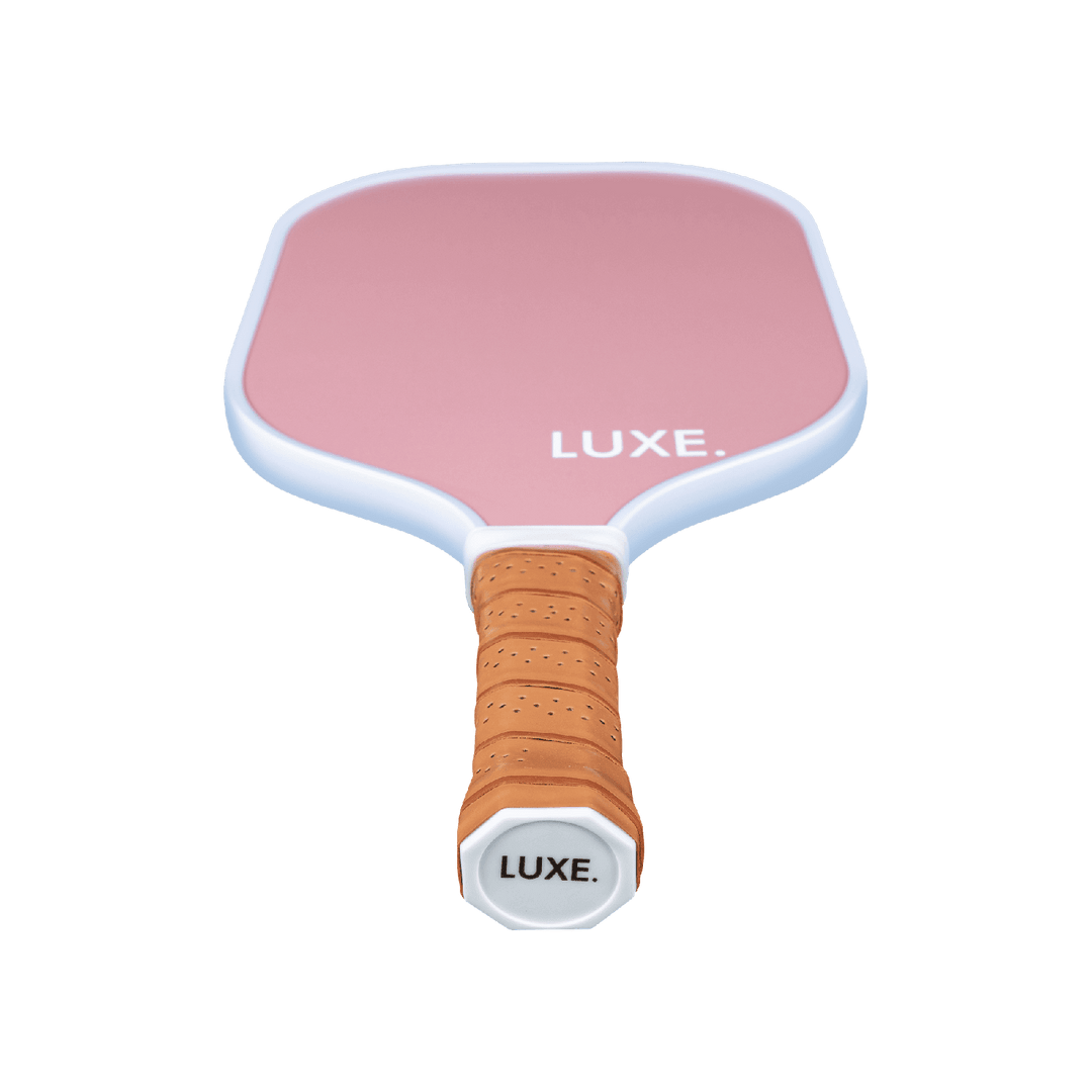 Pink pickleball paddle with brown handle on a transparent background.