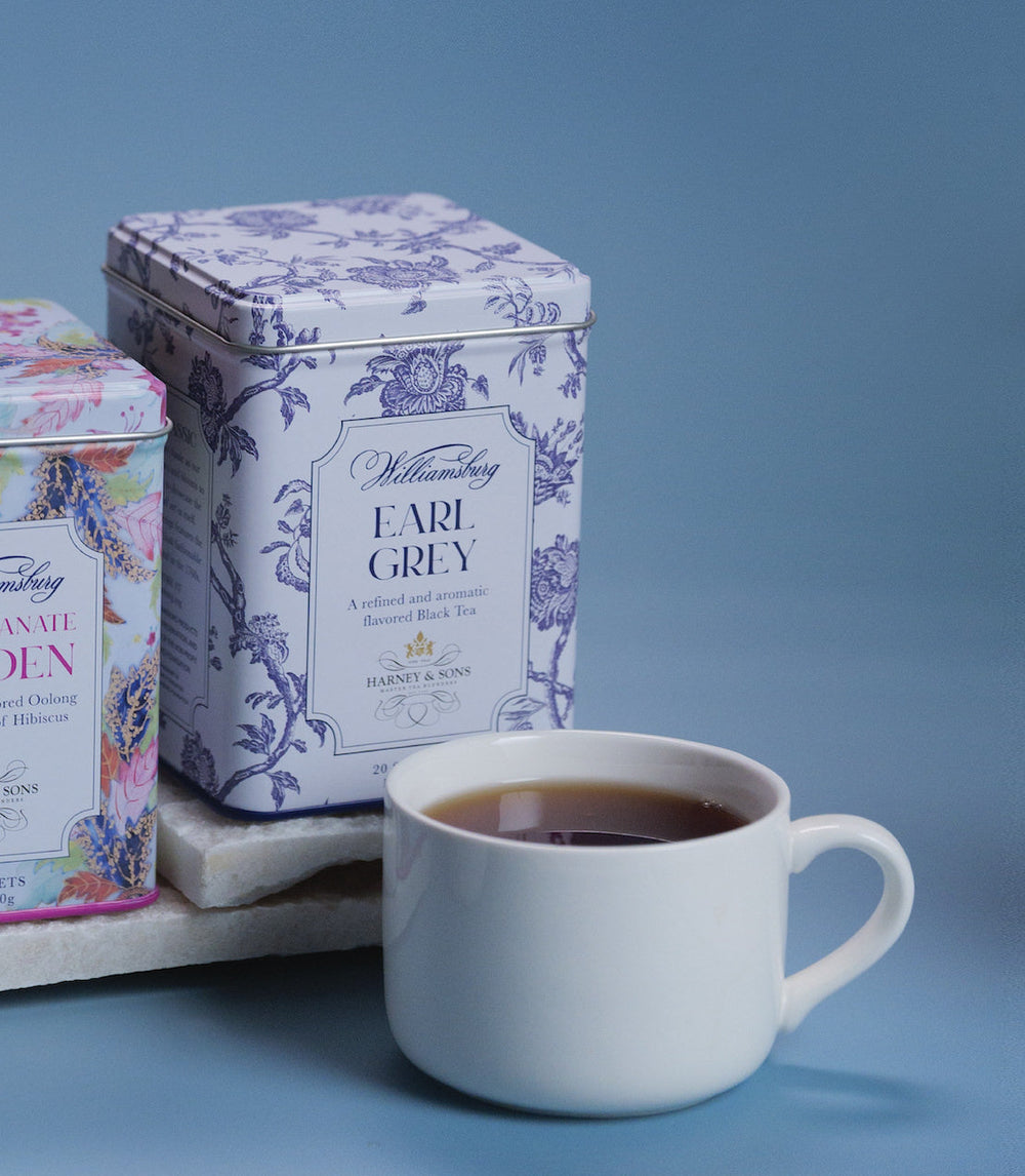 Tea cup with Earl Grey tea packaging on a blue background.