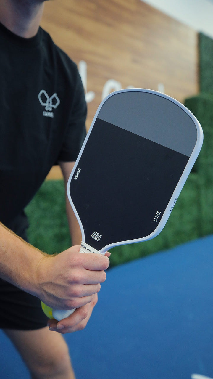 Person holding a pickleball paddle on a court