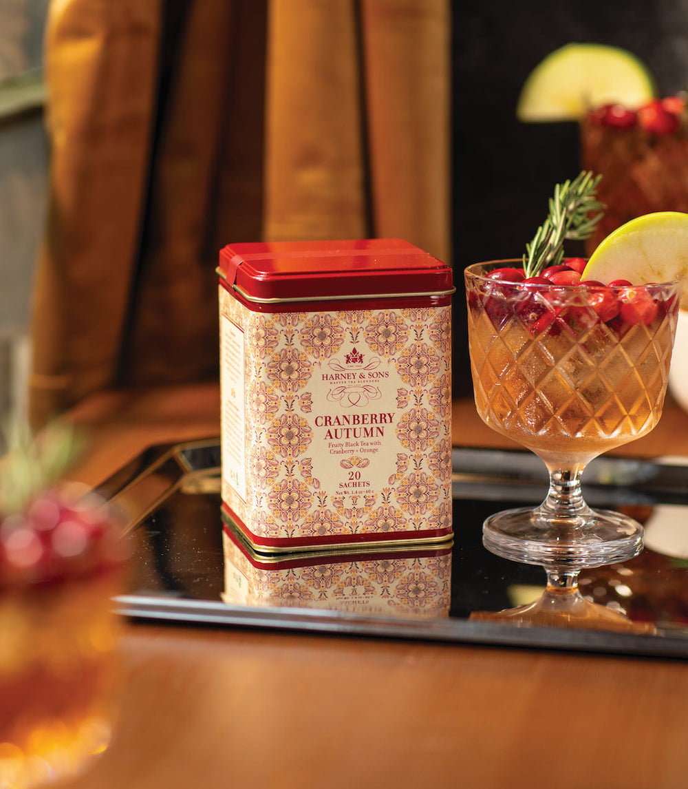 Cranberry autumn tea canister with a cocktail on a tray.
