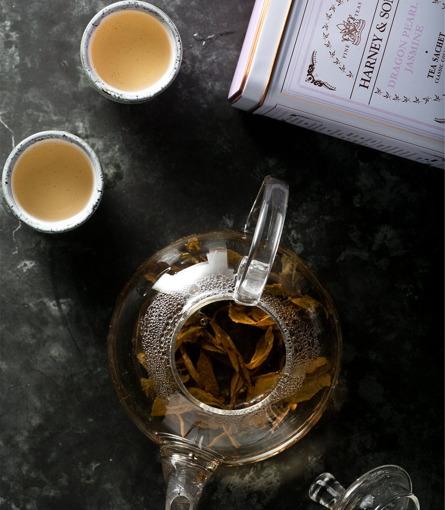 Tea set with Harney & Sons tea on a dark surface.
