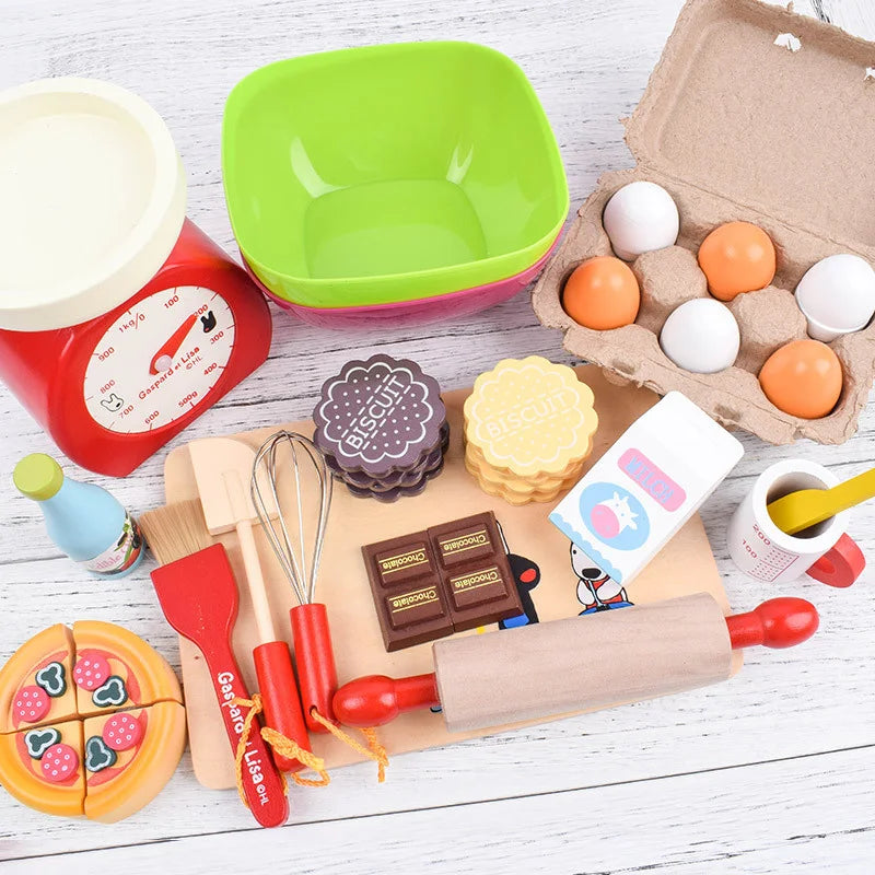 Collection of toy kitchen items including a scale, bowls, and baking tools on a wooden surface.