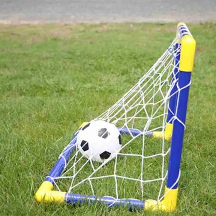 Children's soccer goal with a ball on a grassy field.