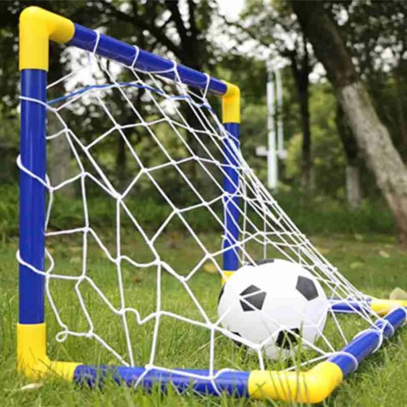 Children's soccer goal with a ball on a grassy field.