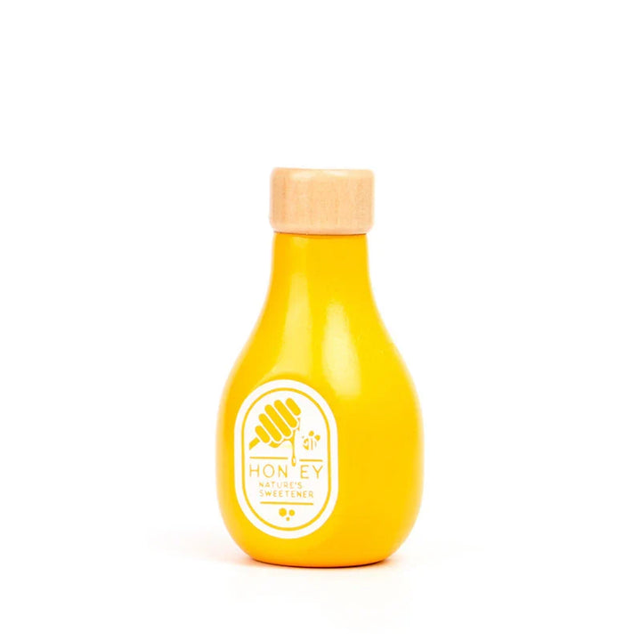 Yellow honey bottle with wooden cap on a white background.