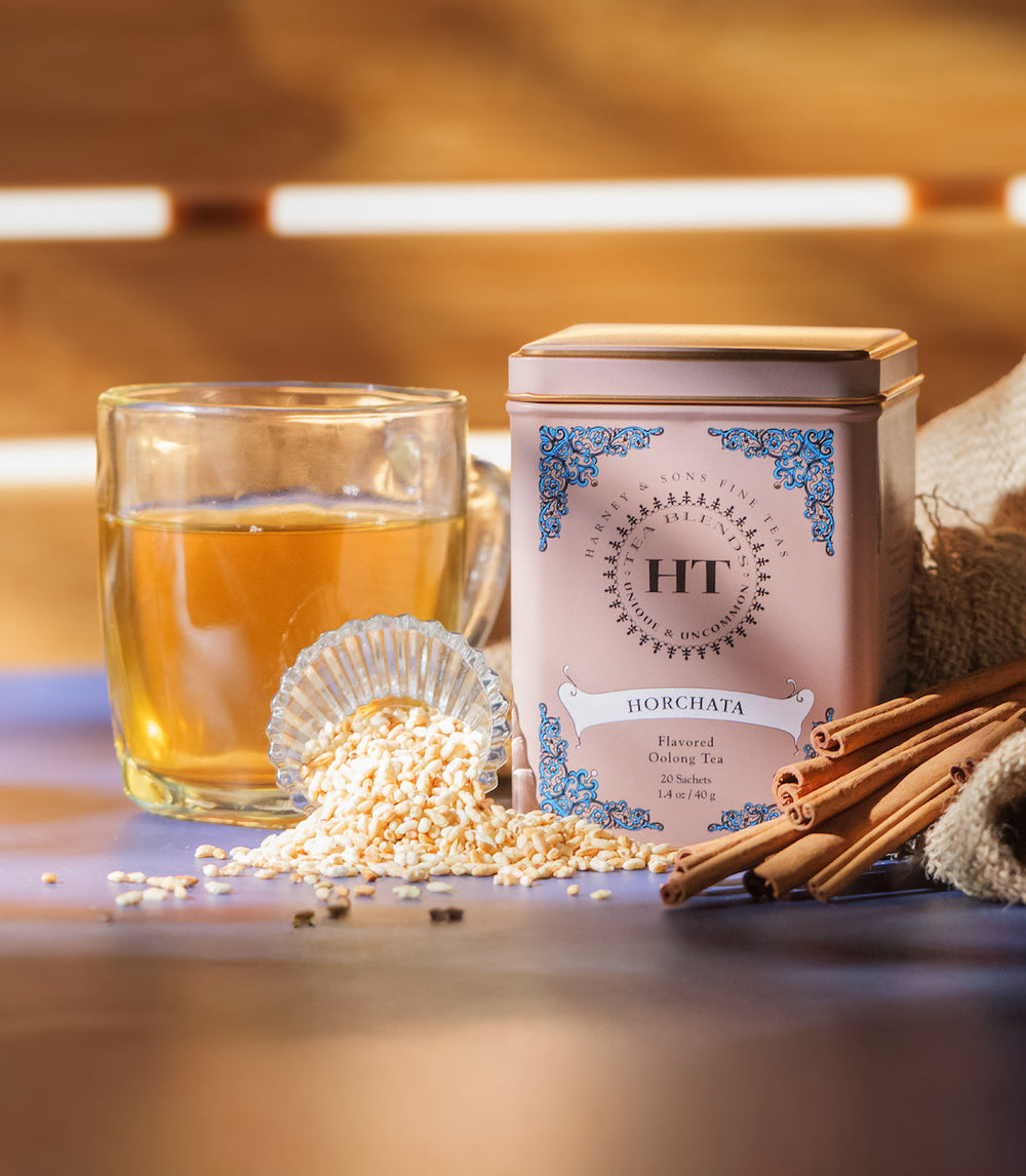 Horchata-flavored iced tea with a tea canister and ingredients on a wooden surface.