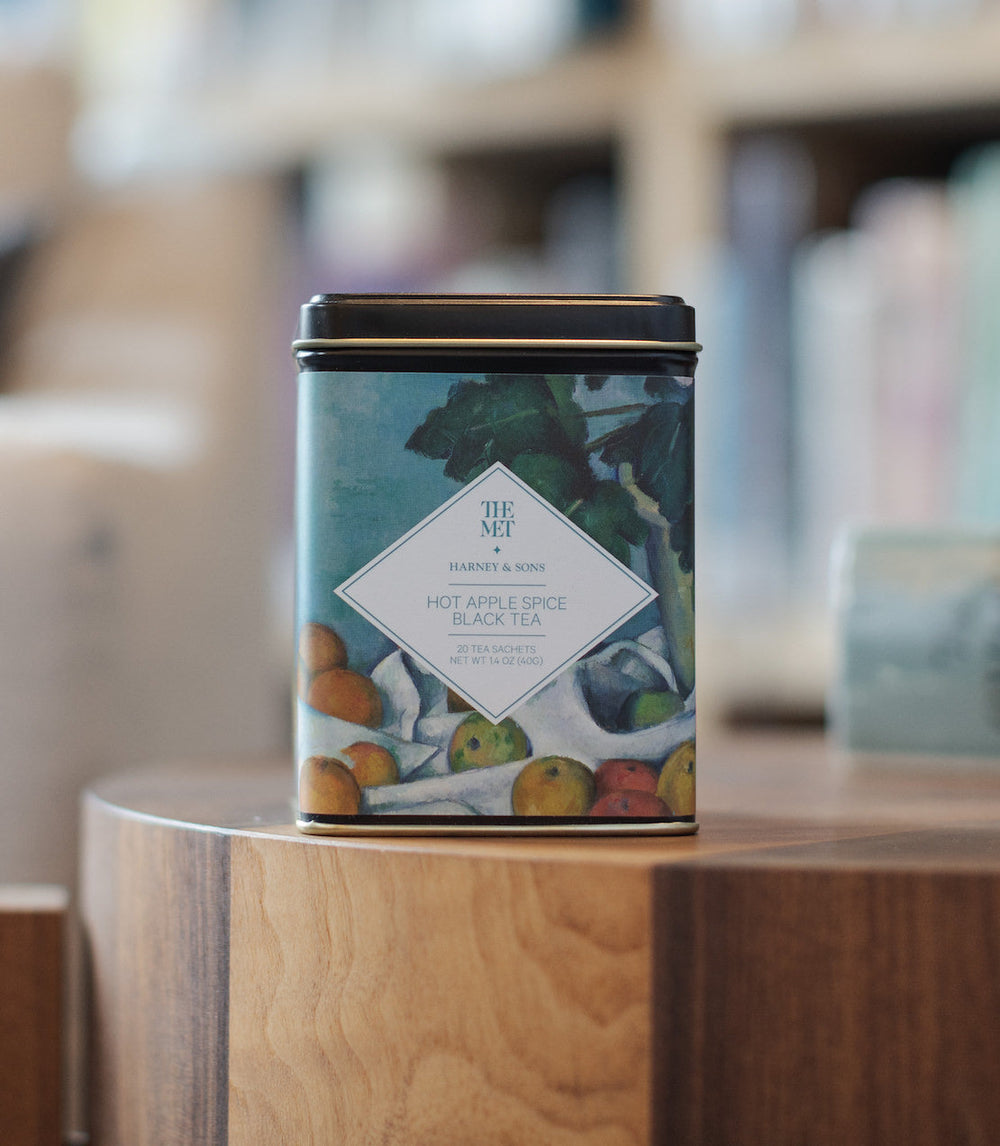 Tea canister with fruit illustration on a wooden surface.