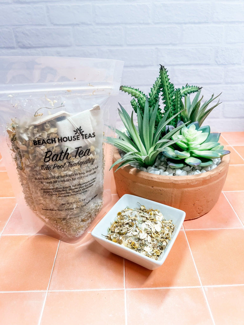 Beach House Teas bath tea package with a potted plant and small bowl on a tiled surface.