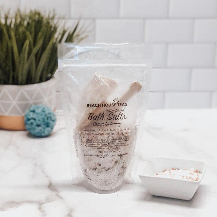 Bag of Beach House Teas bath salts on a marble surface with a plant in the background.
